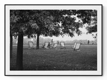 Load image into Gallery viewer, Black and white photograph of striped deckchairs arranged in Hyde Park, London, people relaxing in summer