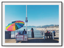 Load image into Gallery viewer, Street photography — Santa Monica Pier in clear January light, the beach, a colourful umbrella and the boardwalk — NEAT Stockholm
